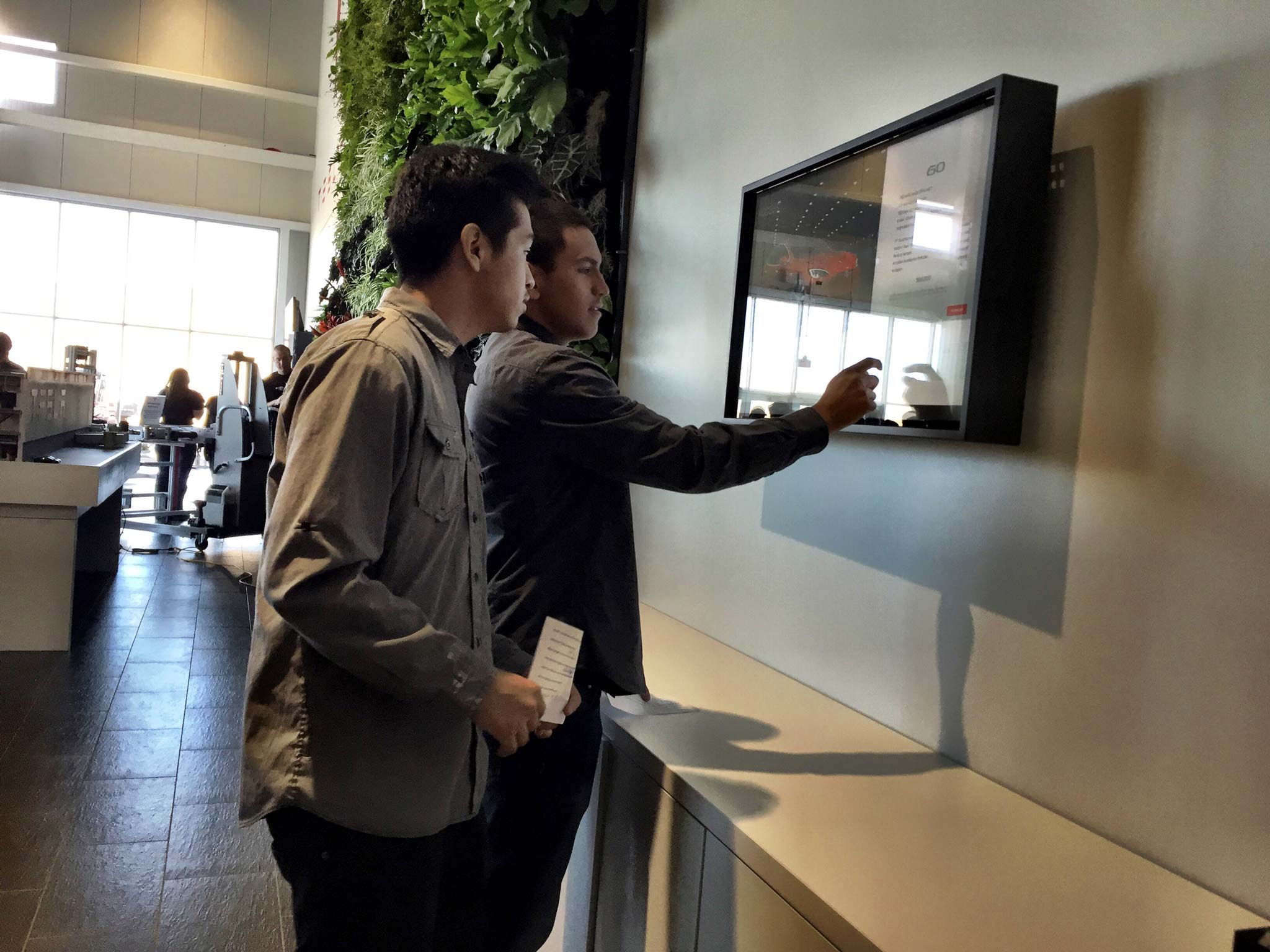 Students exploring a configurator touchscreen (GF1 Lobby)